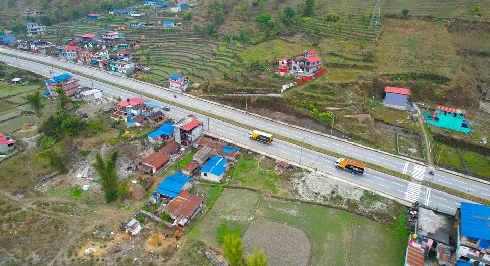 Aerial view of Darshan Transport trucks on the highway through a village