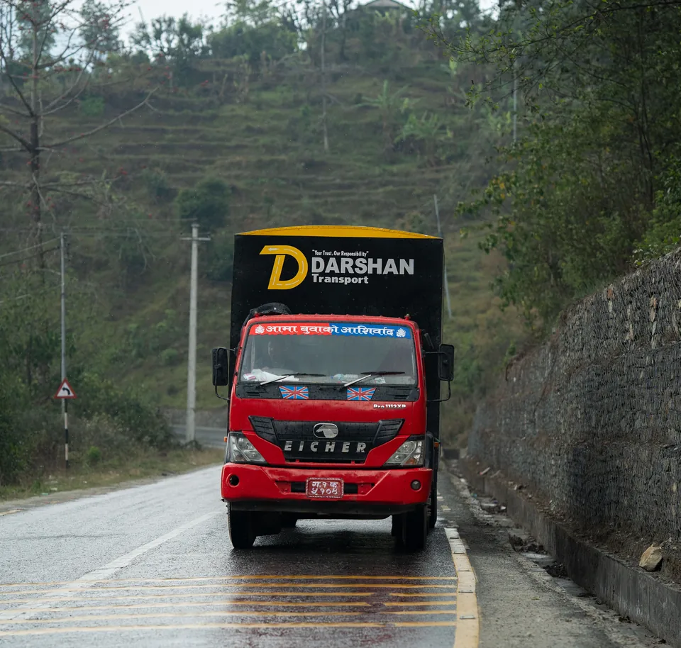 Darshan Transport truck driving a wet mountain road